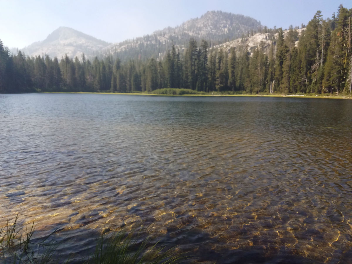 a lake surrounded by trees and mountains