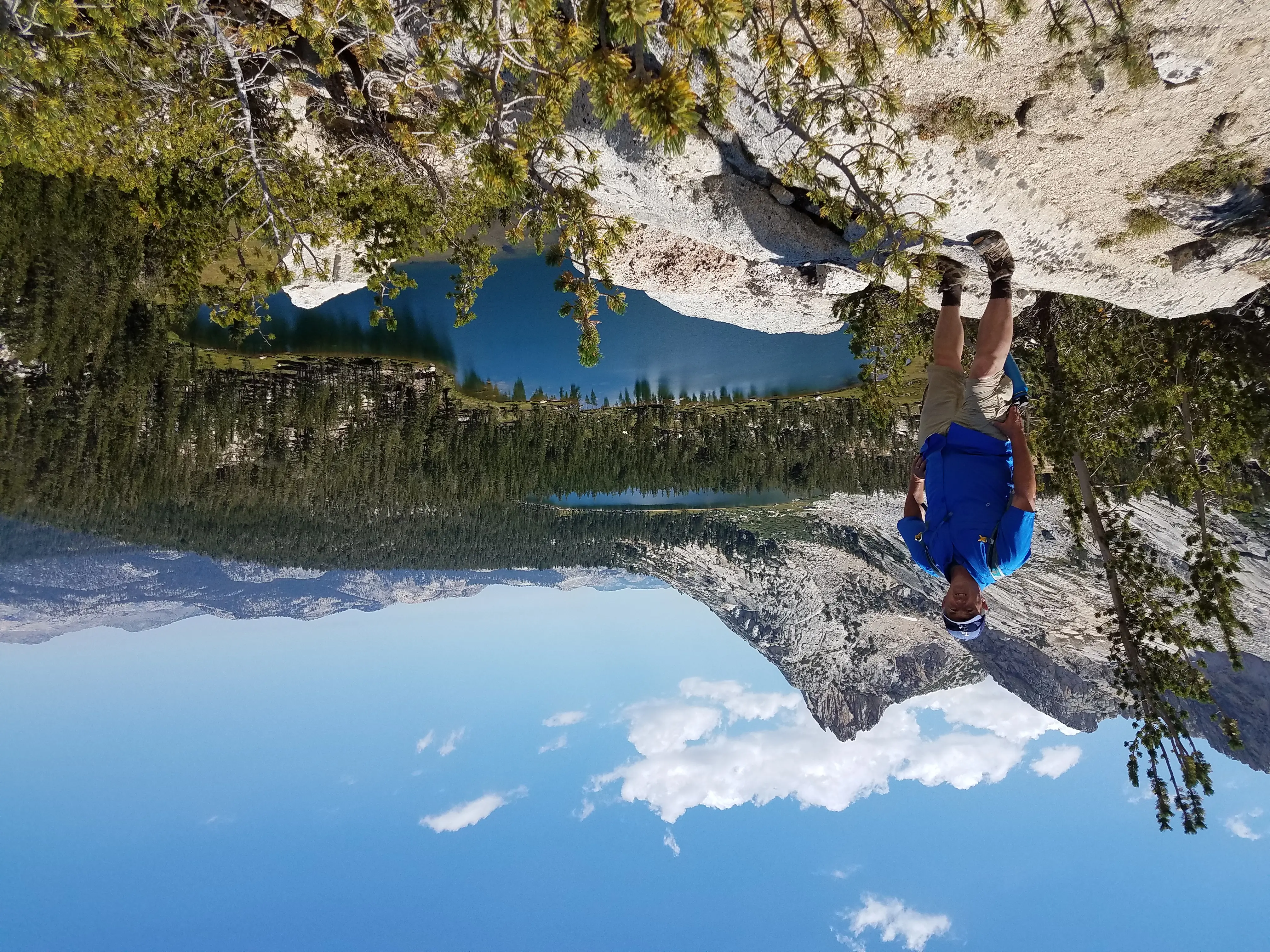 a man standing on a rock overlooking a lake