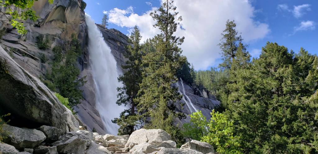 a waterfall is surrounded by rocks and trees