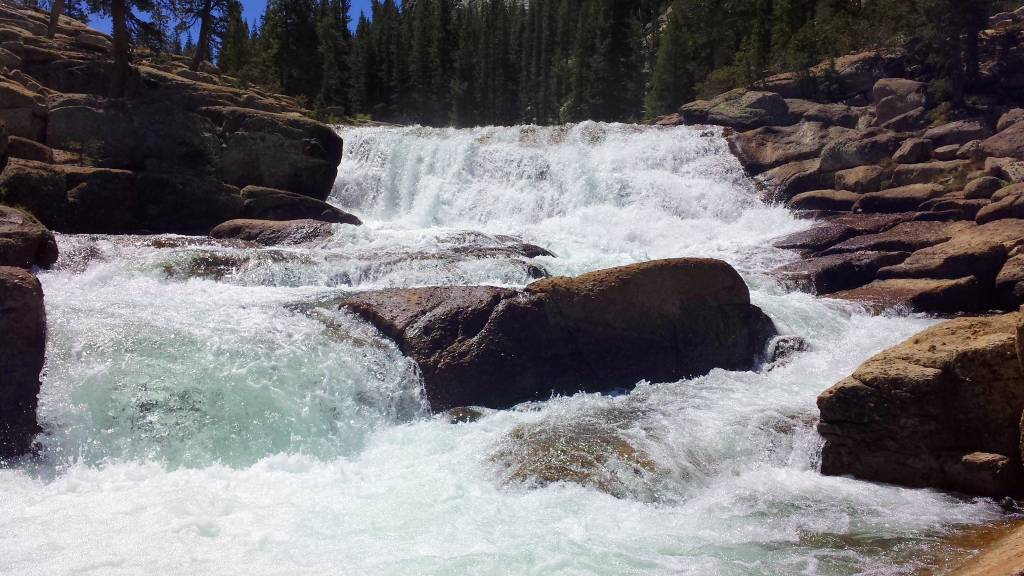 a waterfall is flowing down a rocky mountain