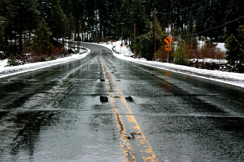 a snowy road with a yellow line