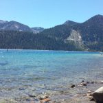 a lake with rocks and trees on the shore