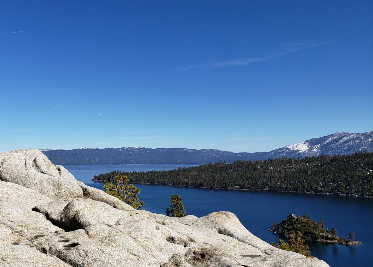a man stands on a rock overlooking a lake