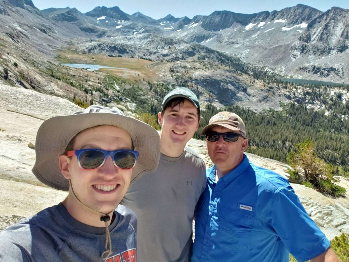 three men in hats and sunglasses taking a selfie