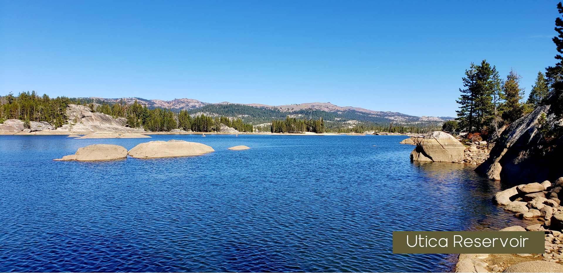 a lake with rocks and trees in the foreground