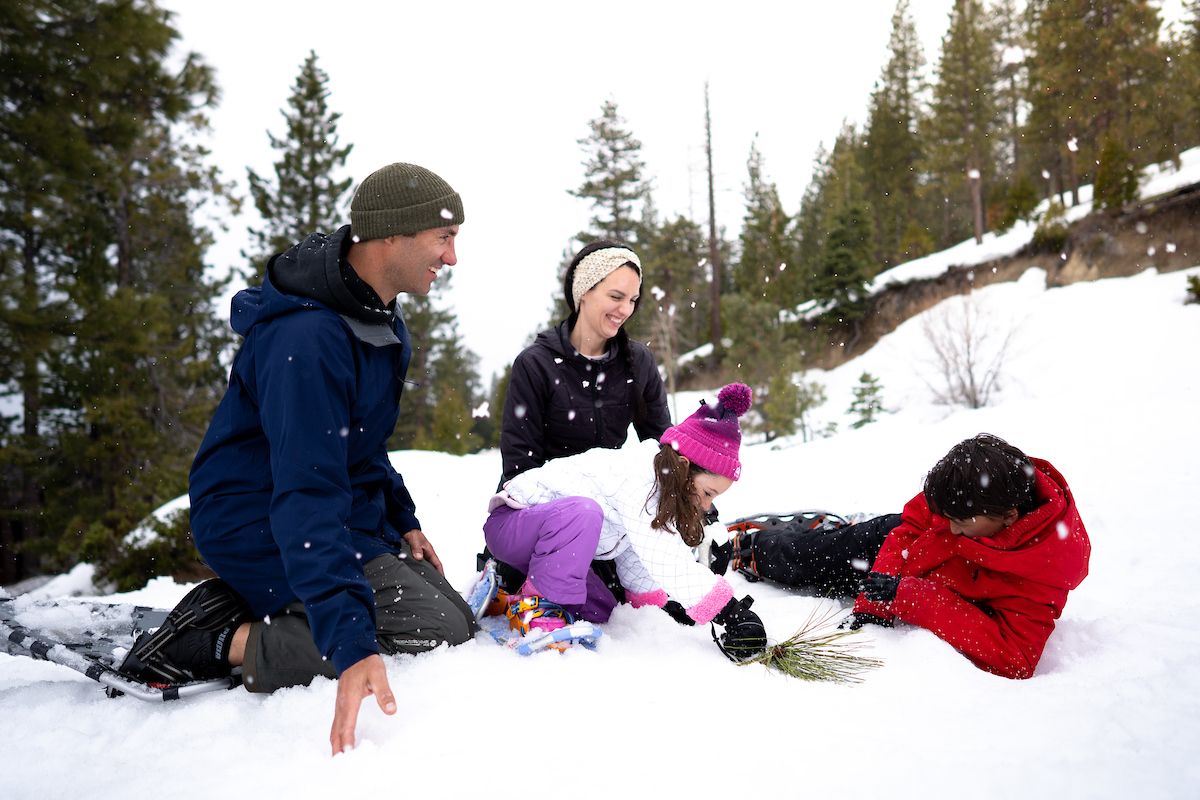 a family of four sitting in the snow