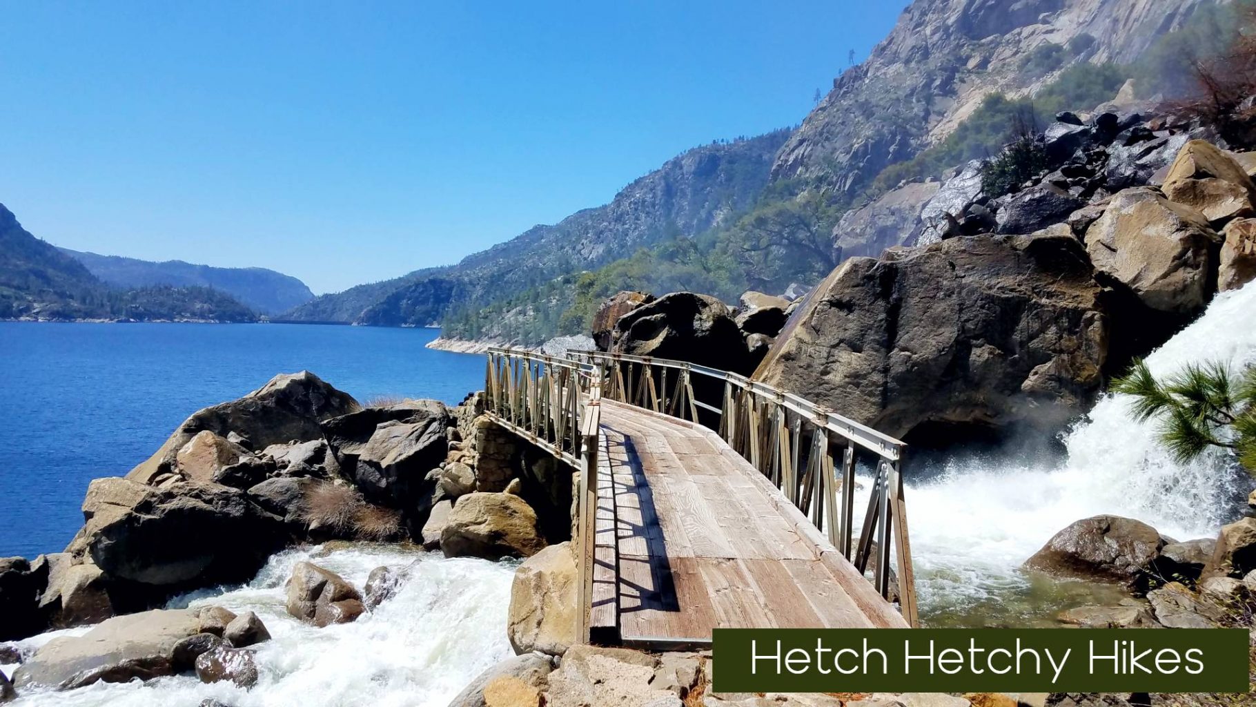 a wooden bridge over a river with water flowing down it
