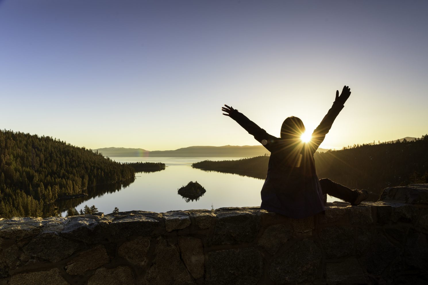 A woman embranced beautiful sunrise at Emerald Lake, California
