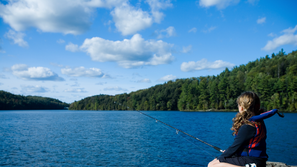 Girl fishing mountain lake forest
