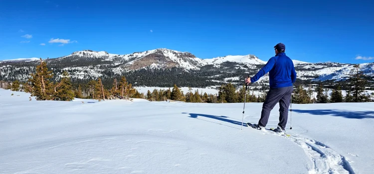Man in Snowshoes overlooking Thunder Mountain and Silver lake in the Sierra