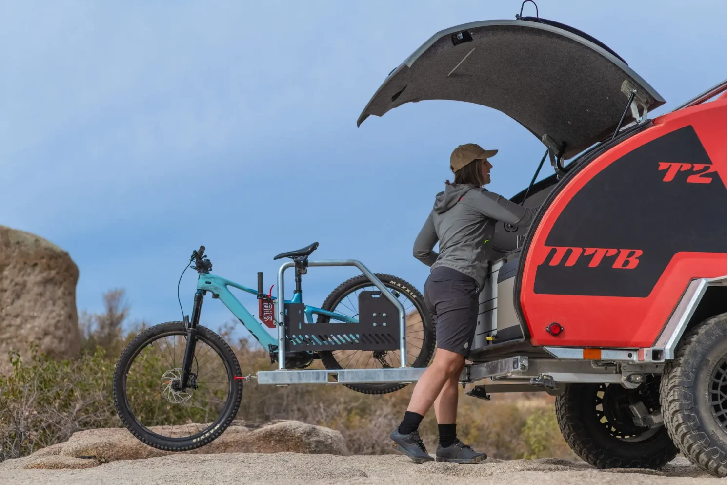 Girl working on her bike with help of Escapod Topo 2 trailer