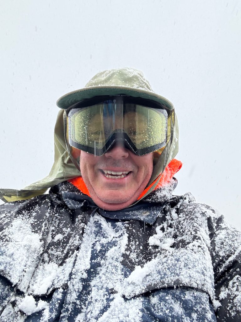 Brian Martz covered in snow with googles fishing